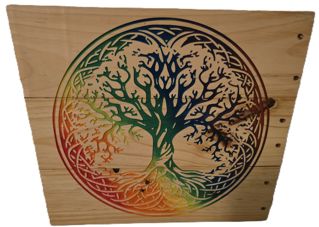 Rainbow tree of life design carved into wood, featuring intricate branches and a gradient of colors from green to red.