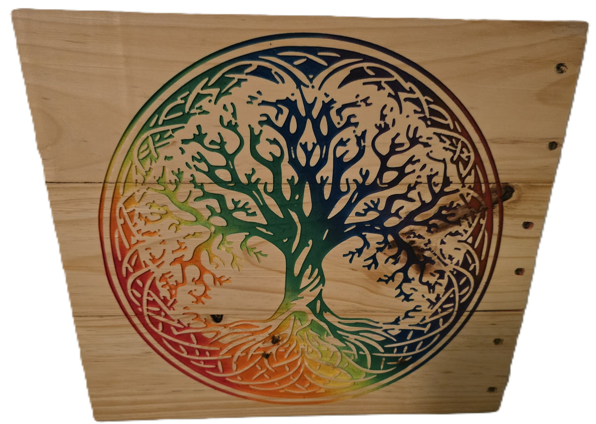 Rainbow tree of life design carved into wood, featuring intricate branches and a gradient of colors from green to red.