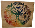 Rainbow tree of life design carved on a wooden panel, featuring vibrant colors transitioning from green to orange.