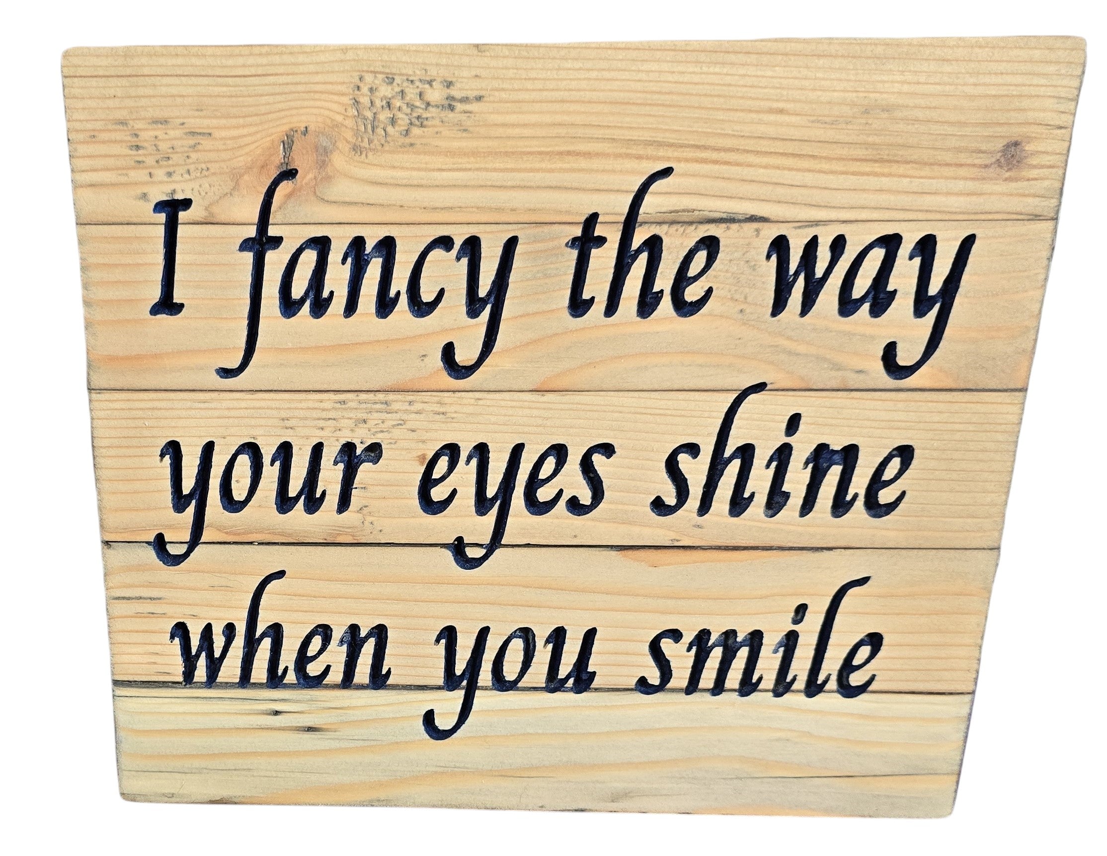 Wooden sign with engraved text: "I fancy the way your eyes shine when you smile.