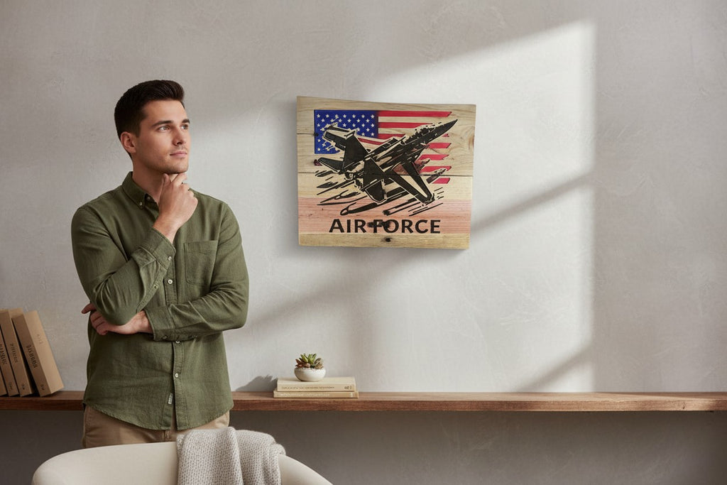 TK Wood Designs wooden sign featuring a black silhouette of an F-18 fighter jet flying over a distressed American flag with "AIR FORCE" text below.