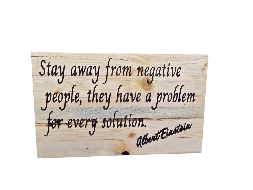 TK Wood Designs Albert Einstein quote wood wall art, "Stay away from negative people, they have a problem for every solution." Black lettering on natural wood planks.