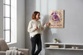 Woman pointing at TK Wood Designs Aquarius zodiac wall art with purple engraved details on natural wood grain.