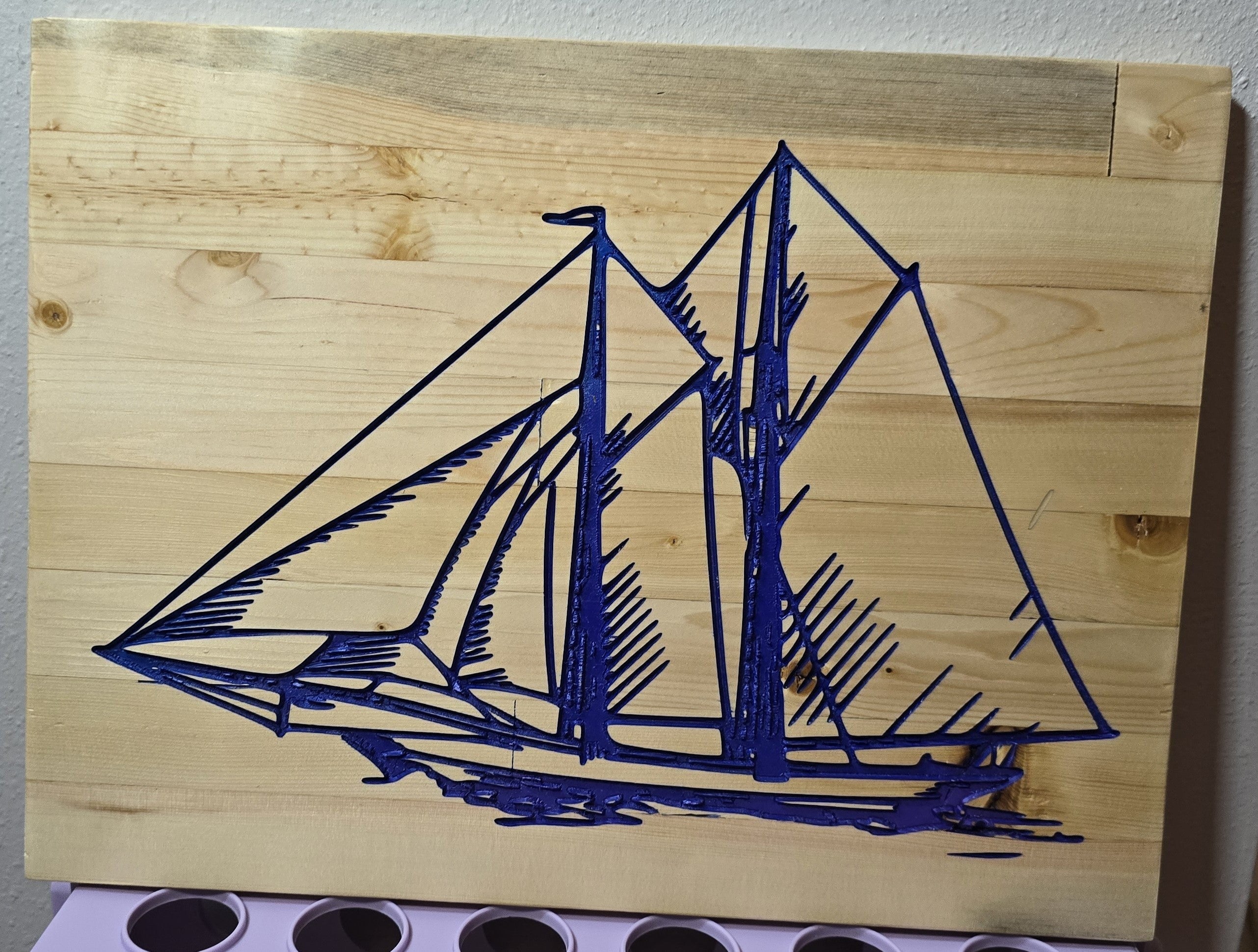 TK Wood Designs blue sailboat carved into light wood panel wall art