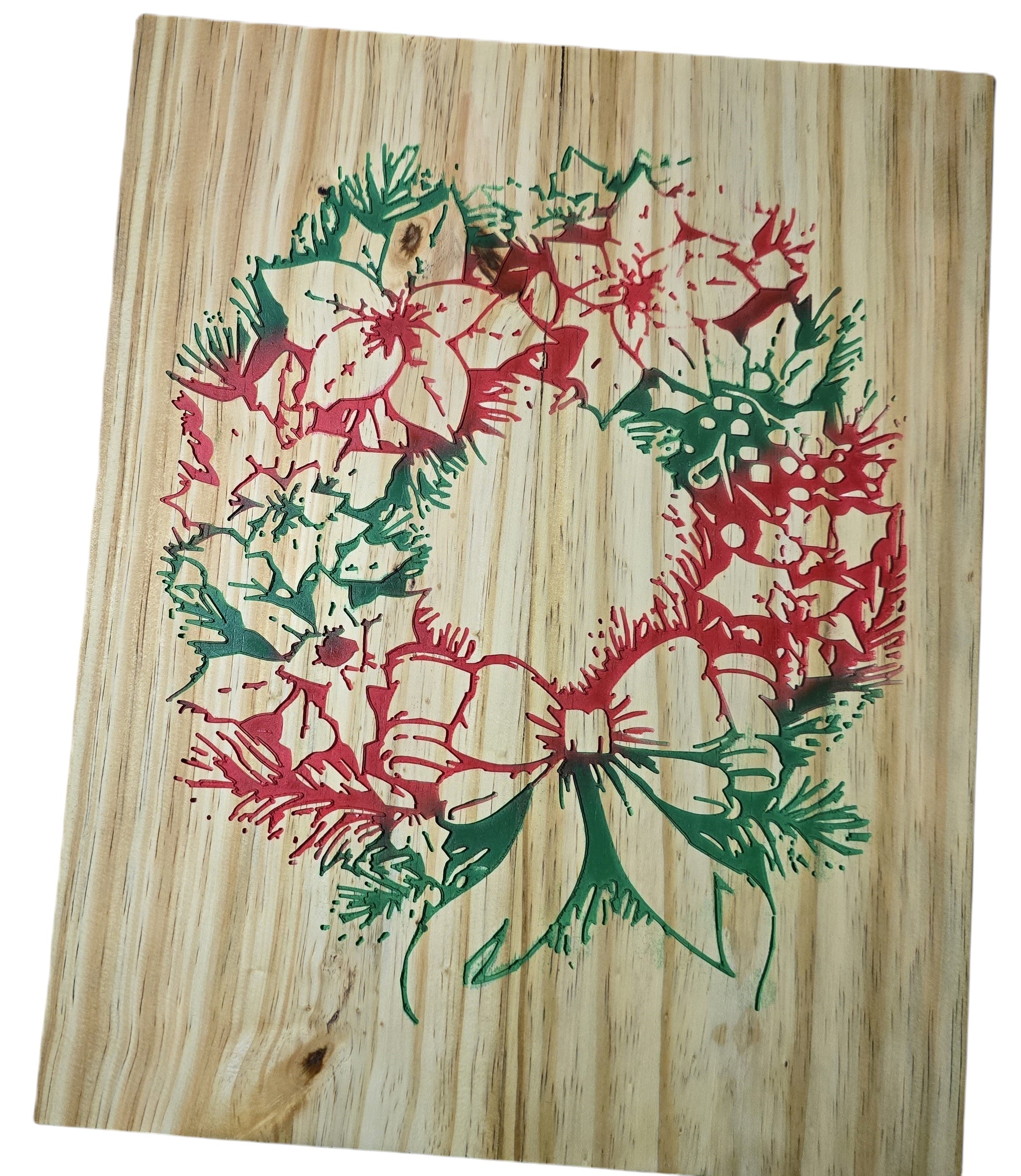 TK Wood Designs rustic Christmas wreath on wood, featuring red poinsettias and green pine boughs with a bow.