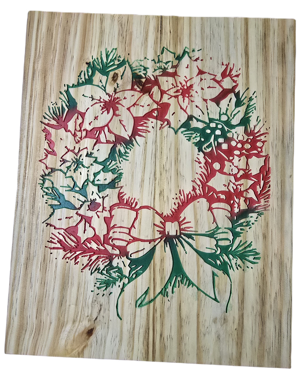 TK Wood Designs rustic Christmas wreath carved into wood, featuring red poinsettias and green pine sprigs with a bow.