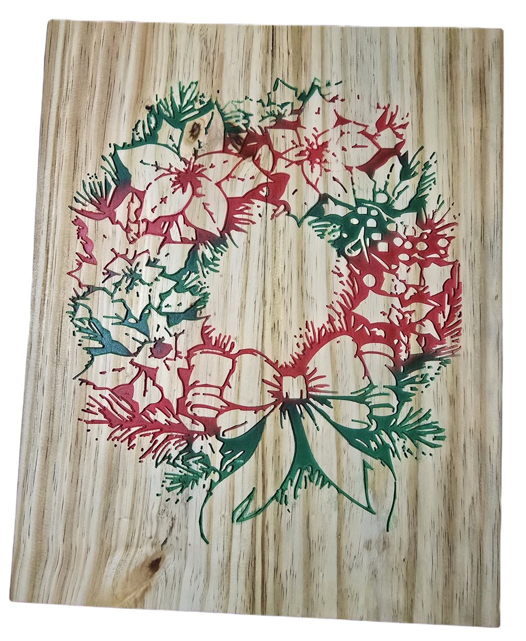 TK Wood Designs rustic Christmas wreath carved into wood, featuring red poinsettias, green pine needles, and a green bow.
