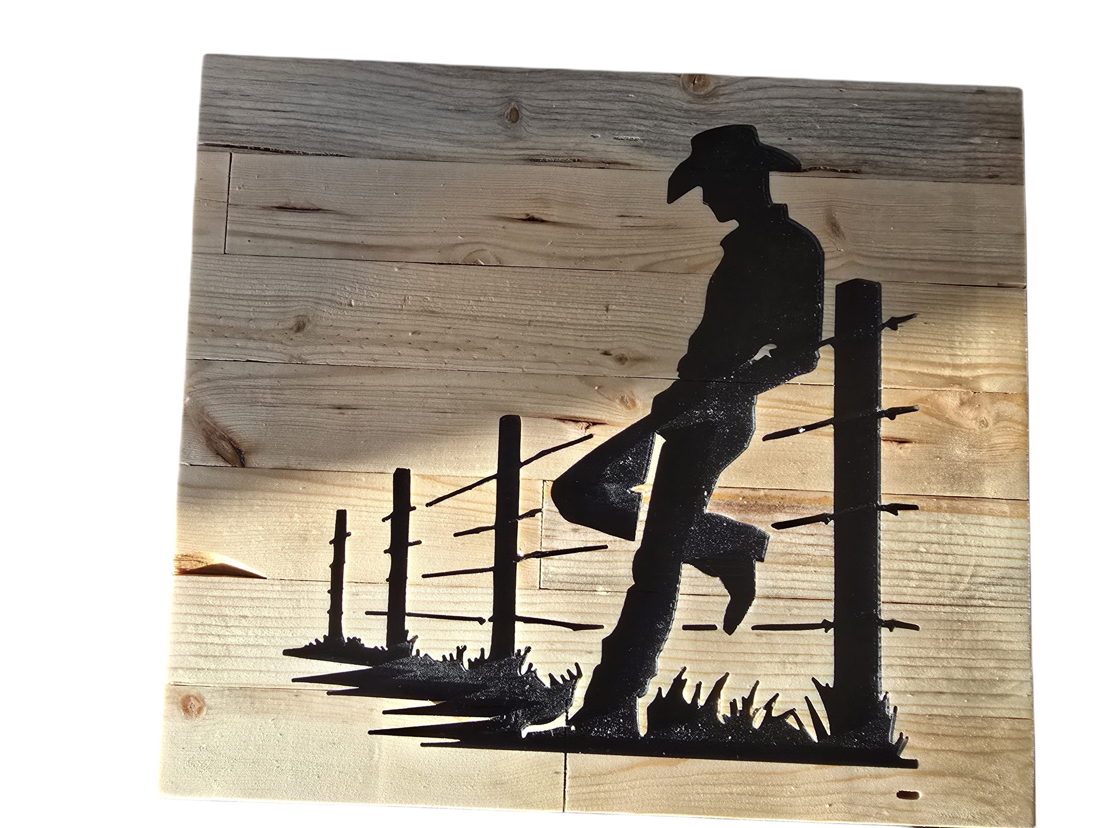 TK Wood Designs rustic cowboy silhouette leaning on a fence, crafted from salvaged wood with visible grain.