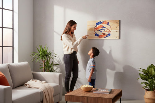 Woman and child looking at a TK Wood Designs Denver Broncos wooden wall sign in a modern living room.