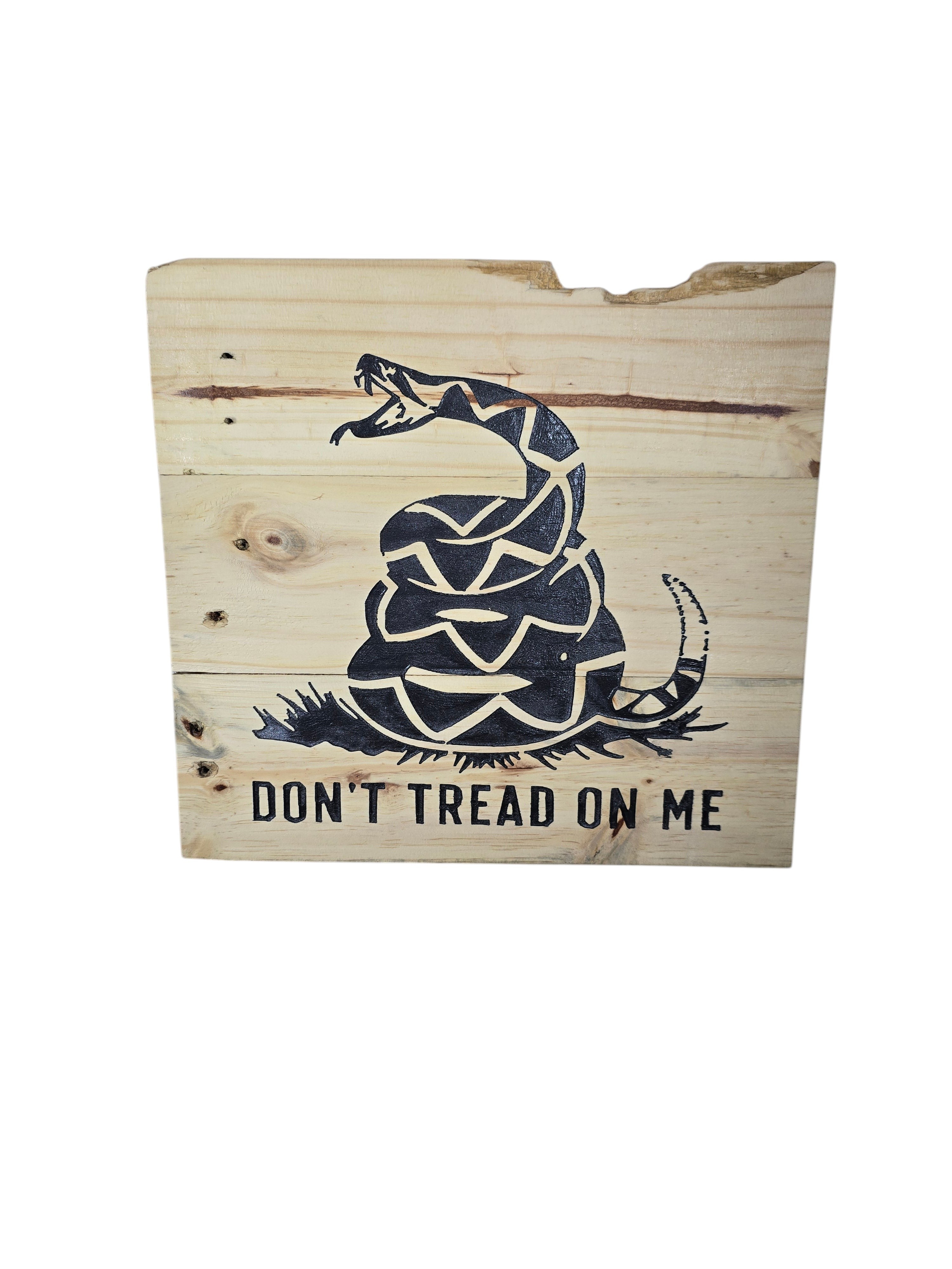 TK Wood Designs natural wood wall art featuring a coiled rattlesnake graphic and "Don't Tread On Me" text. Rustic, patriotic.