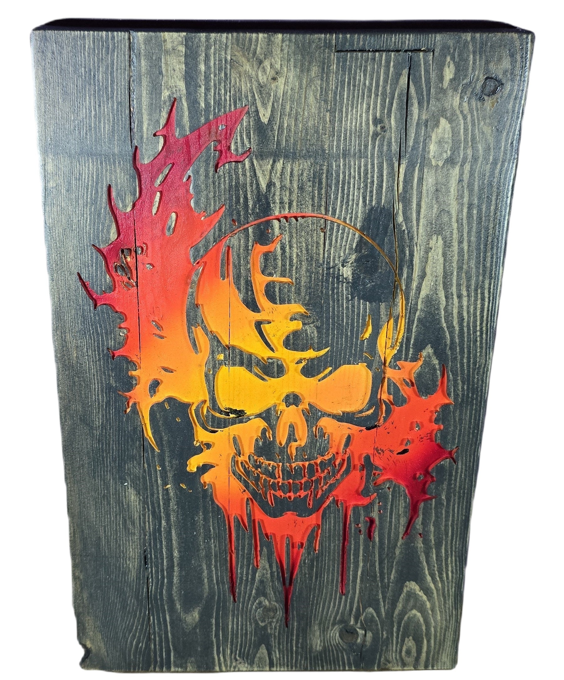 TK Wood Designs distressed wood wall art featuring a fiery skull in red, orange, and yellow. Rustic texture.