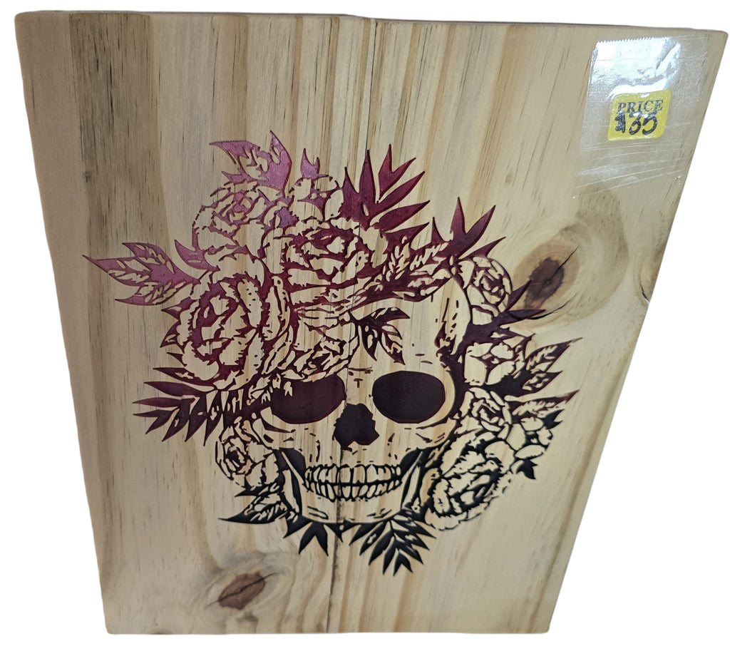 TK Wood Designs natural wood wall art featuring a skull with floral accents in burgundy and black. Unique macabre decor.