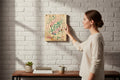 TK Wood Designs Gemini zodiac wall art featuring colorful twins on natural wood hanging on a white brick wall
