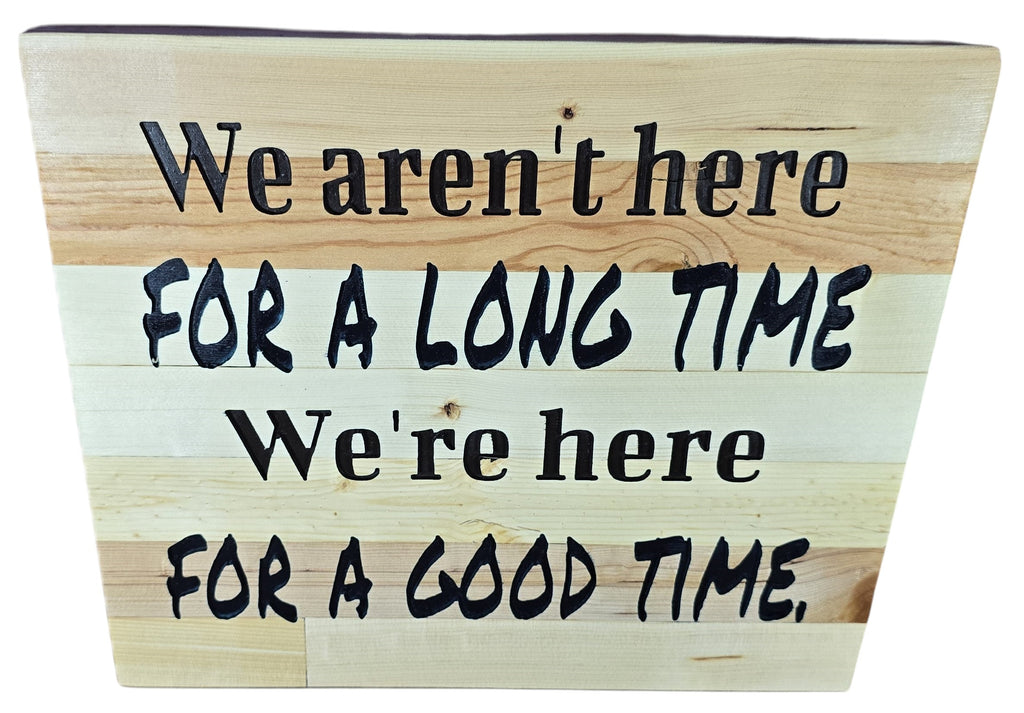 TK Wood Designs natural wood sign with black lettering: "We aren't here for a long time, we're here for a good time."
