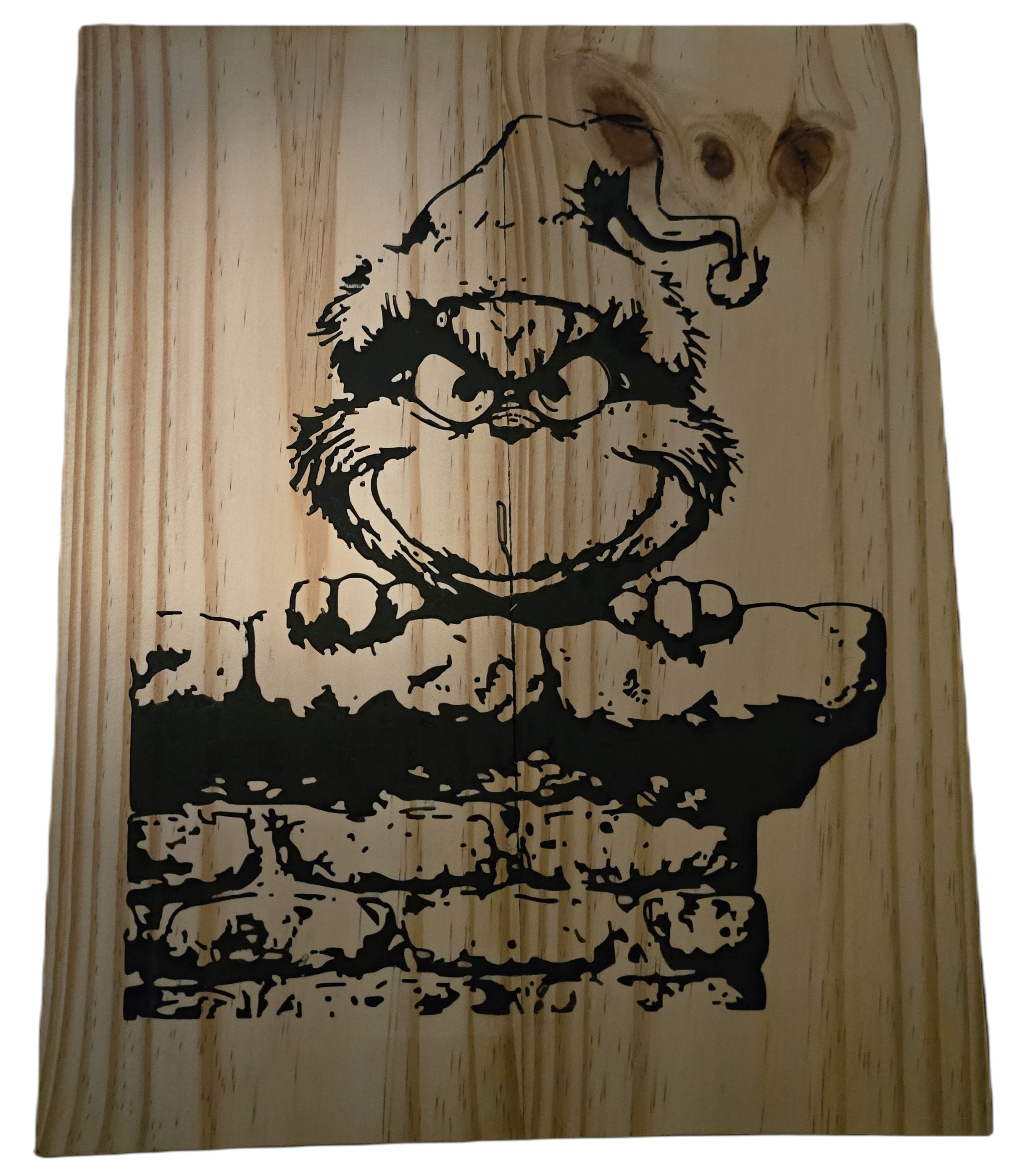 TK Wood Designs Grinch salvaged wood sign with black graphic of the Grinch peeking over a brick wall.