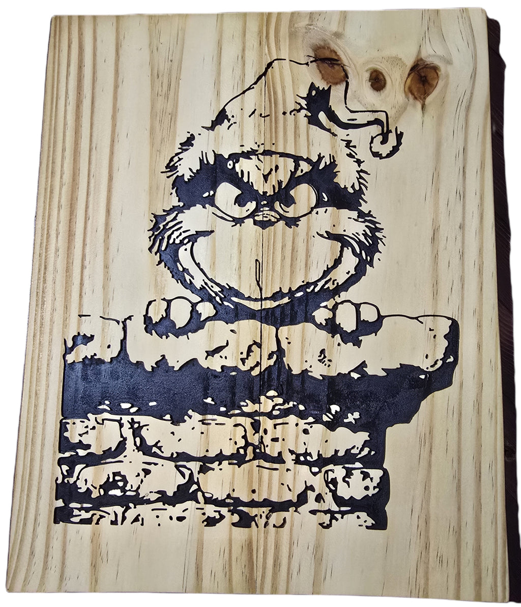 TK Wood Designs Grinch wood sign featuring the character peeking over a brick wall. Natural wood grain.