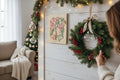 TK Wood Designs decorative holiday bell wood wall hanging with festive holly art displayed on a rustic white wall.