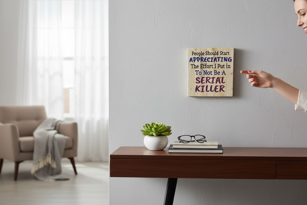 TK Wood Designs wooden sign with humorous quote "People Should Start Appreciating The Effort I Put in To Not Be A SERIAL KILLER" in black, blue, and purple lettering.