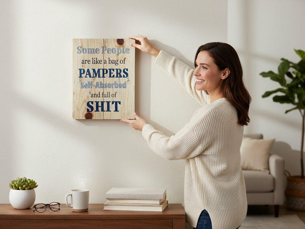 Woman hanging a TK Wood Designs rustic wooden wall sign with humorous text on a white living room wall.