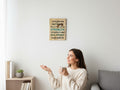 A woman in a cream sweater looks at a TK Wood Designs humorous wooden wall sign hanging on a white living room wall.