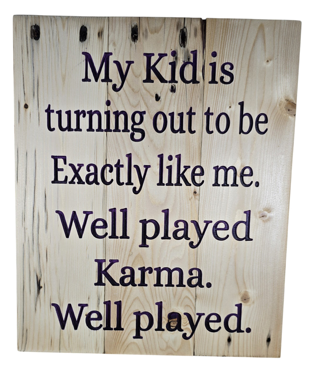 TK Wood Designs natural wood sign with dark purple text reading "My Kid is turning out to be Exactly like me. Well played Karma. Well played."