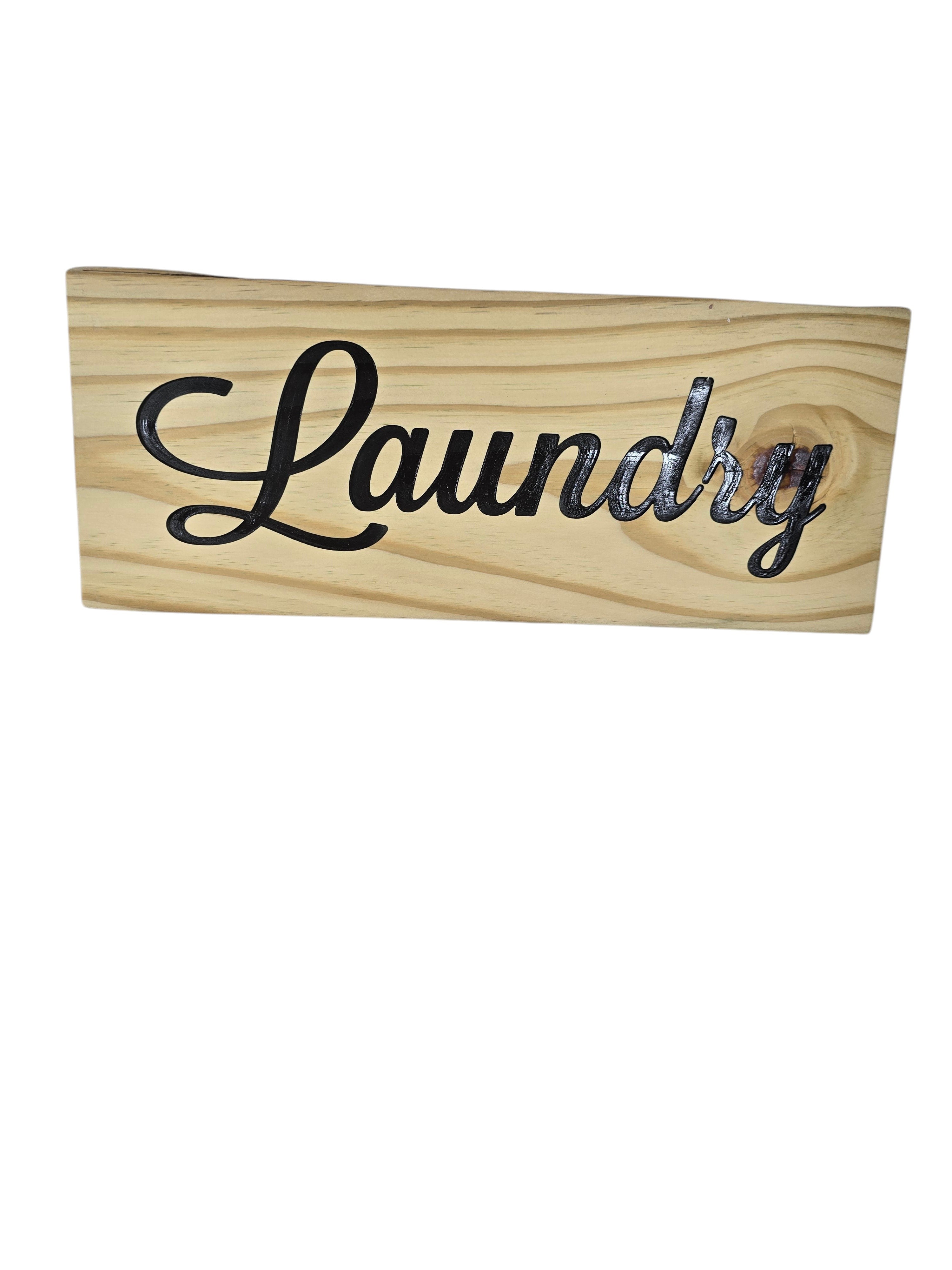 TK Wood Designs rustic light wood sign with black script lettering that says Laundry.