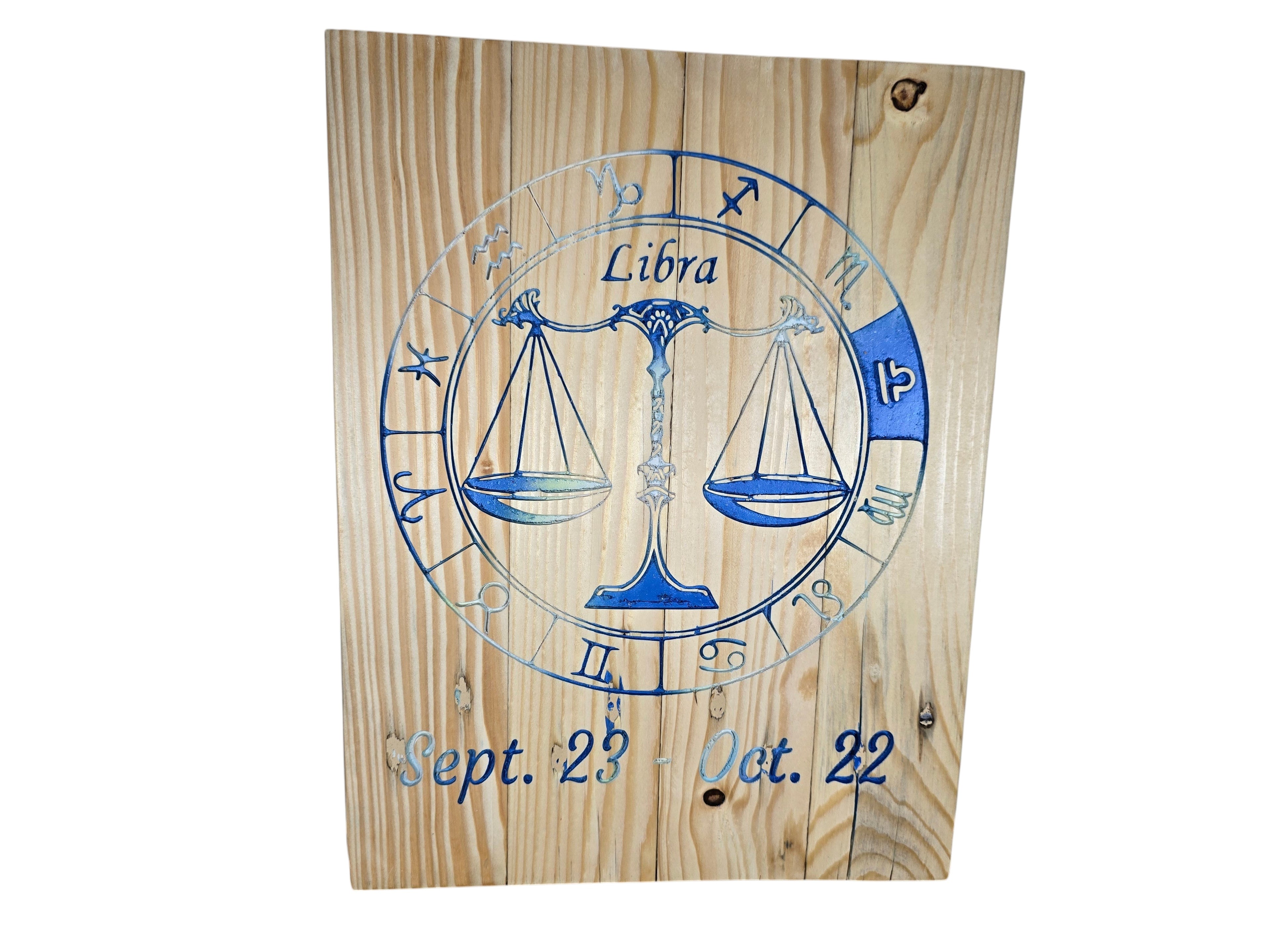 TK Wood Designs Libra zodiac wall plaque with blue engraved scales and dates on natural wood grain background.