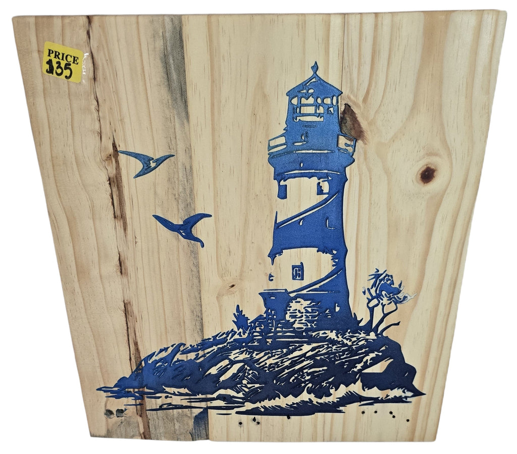 TK Wood Designs natural wood wall art featuring a blue lighthouse on a rocky shore with seagulls. Coastal theme.