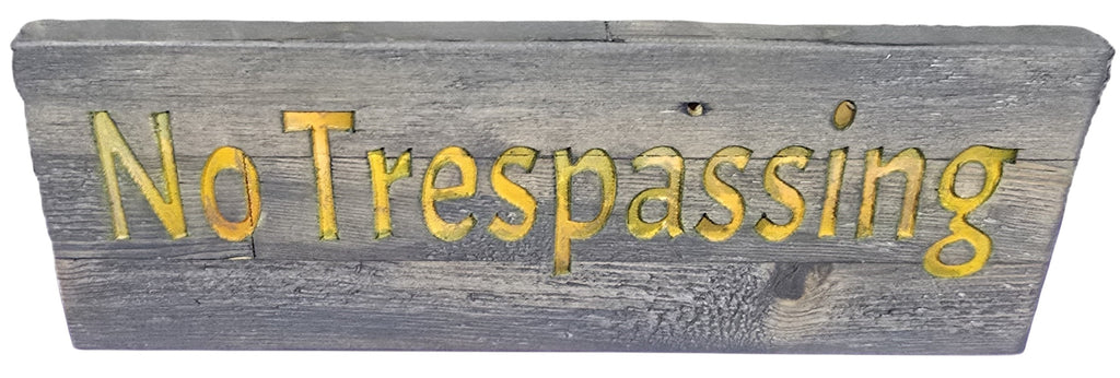 TK Wood Designs No Trespassing wooden sign with routed yellow lettering on distressed grey wood.