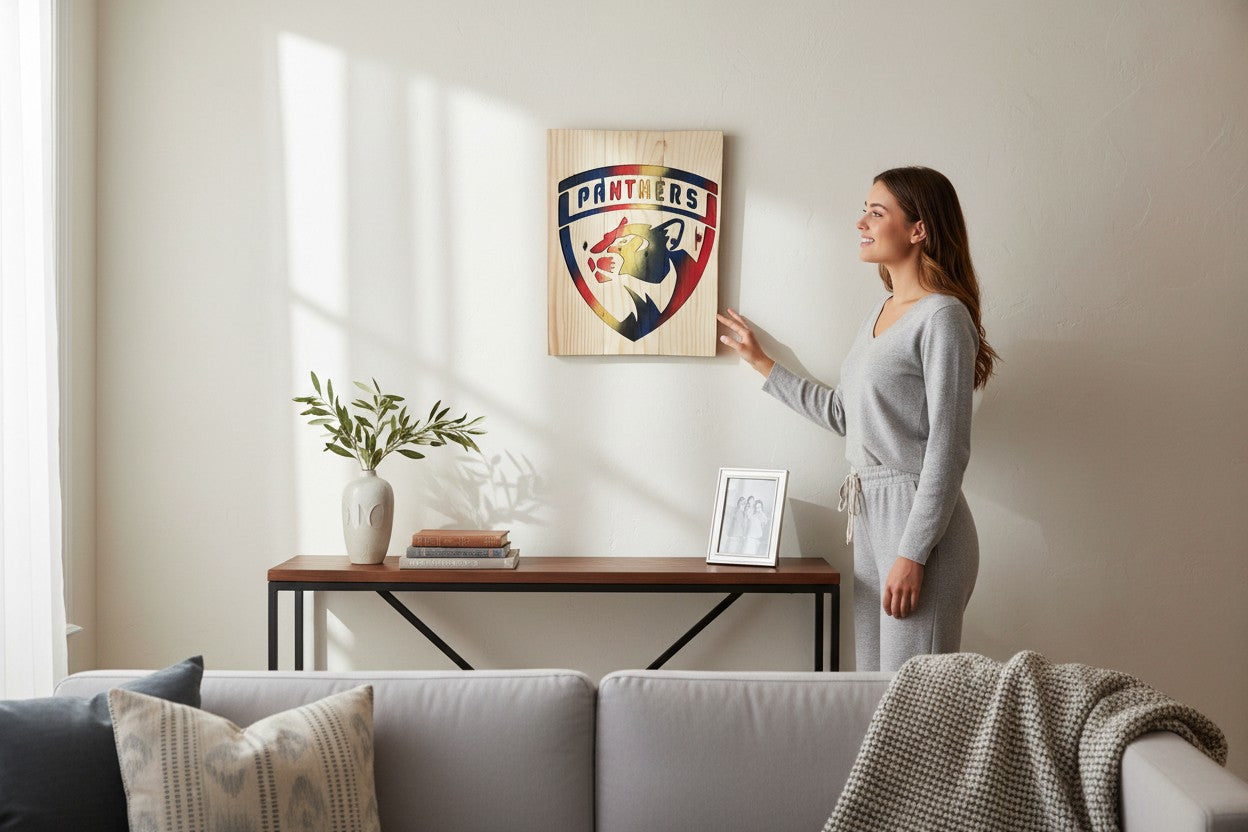 Woman touching a handcrafted TK Wood Designs wooden Panthers sports team wall art plaque in a modern living room.