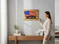 A woman hanging TK Wood Designs patriotic wooden wall art featuring a soldier silhouette and distressed American flag.