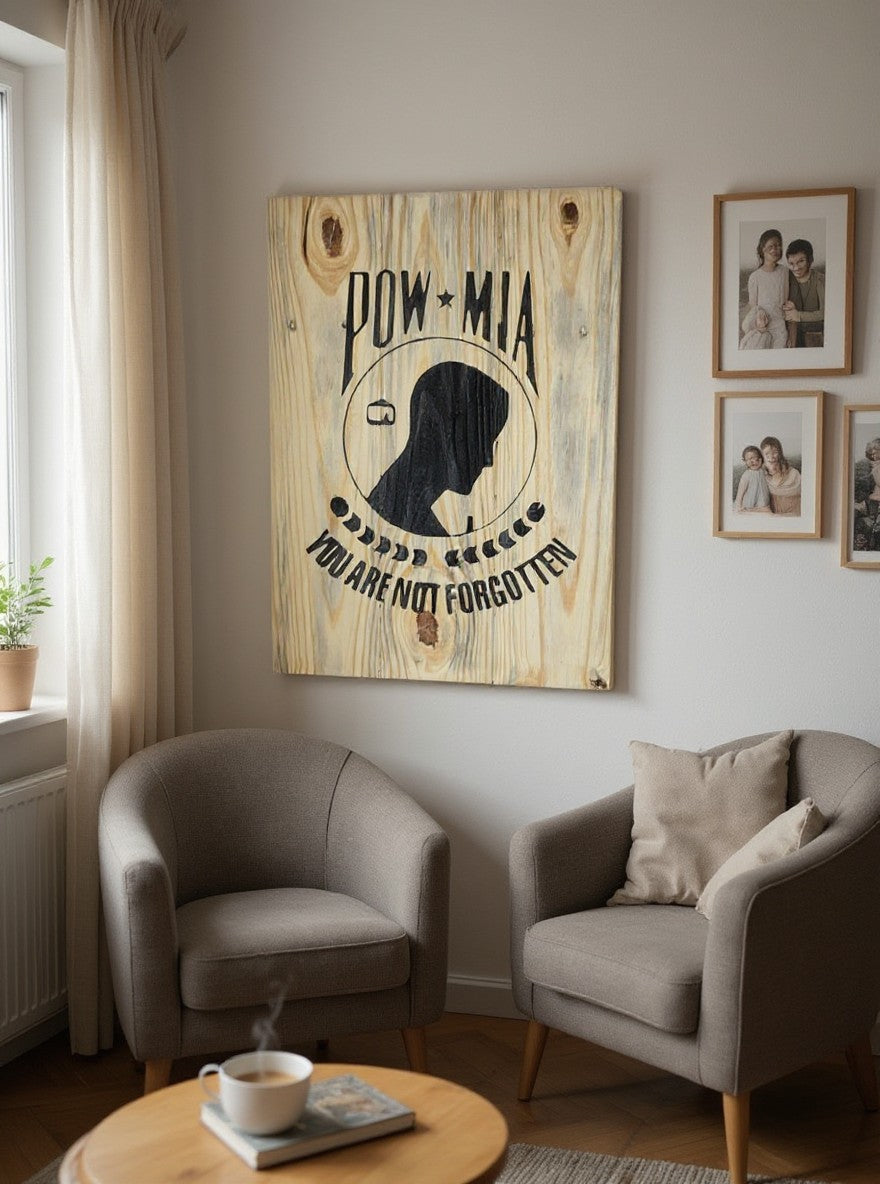 TK Wood Designs POW-MIA wooden wall sign with black silhouette and text hanging above two grey armchairs in a room.