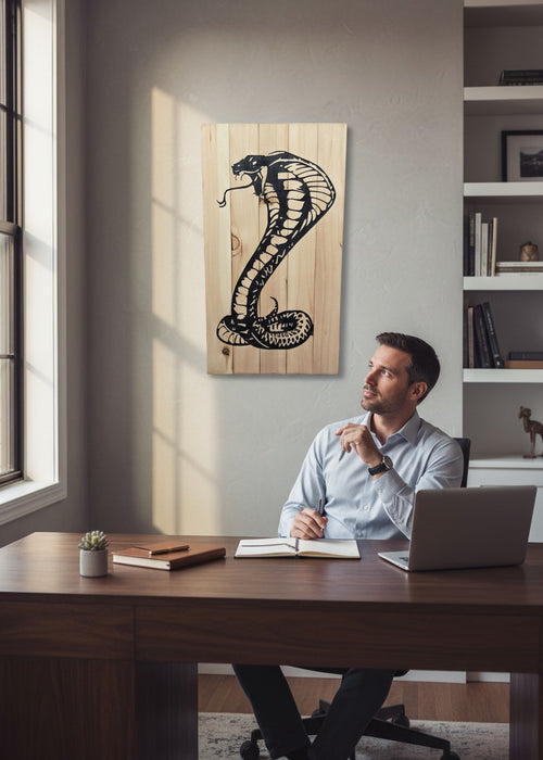 TK Wood Designs carved cobra snake sculpture from reclaimed wood, black silhouette on natural wood grain.