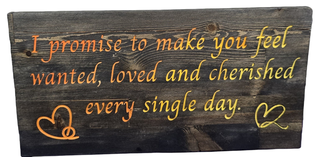 TK Wood Designs reclaimed wood sign with orange and yellow text reading 'I promise to make you feel wanted, loved and cherished every single day.' Includes heart designs.