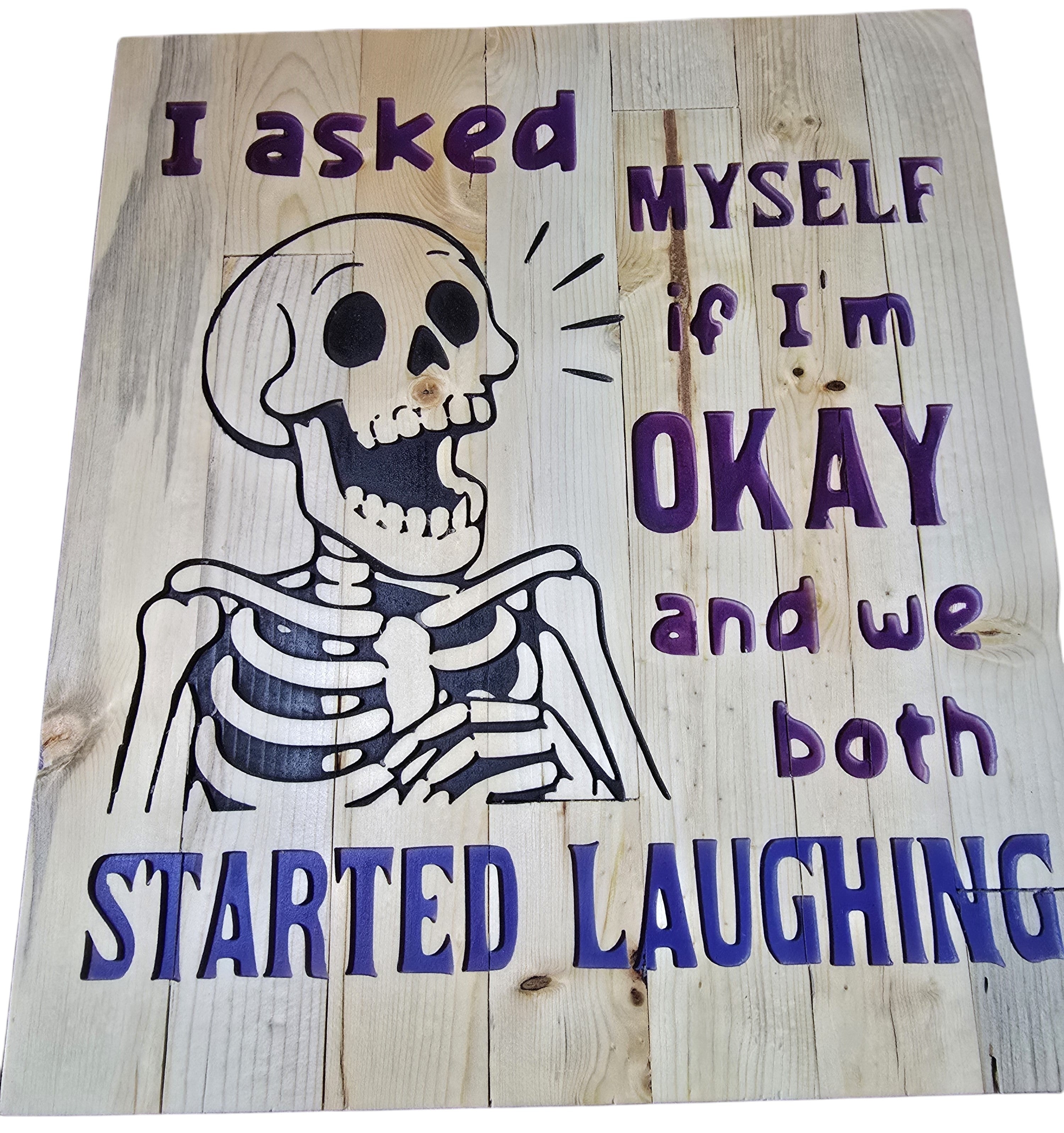 TK Wood Designs reclaimed wood sign with carved skeleton and purple text reading 'I asked myself if I'm okay and we both started laughing'.