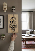TK Wood Designs reclaimed wood skull sign, featuring a cluster of black-outlined skulls with distressed details. Natural wood grain visible.