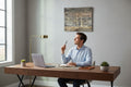 TK Wood Designs rustic wooden sailboat wall art hanging in a modern home office above a man at a desk.