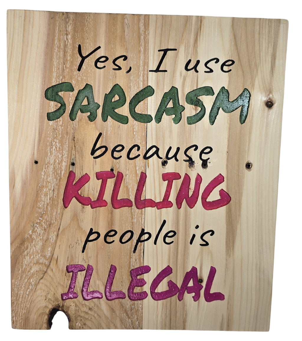 TK Wood Designs natural wood sign with bold green, pink, and black lettering that reads "Yes, I use SARCASM because KILLING people is ILLEGAL."