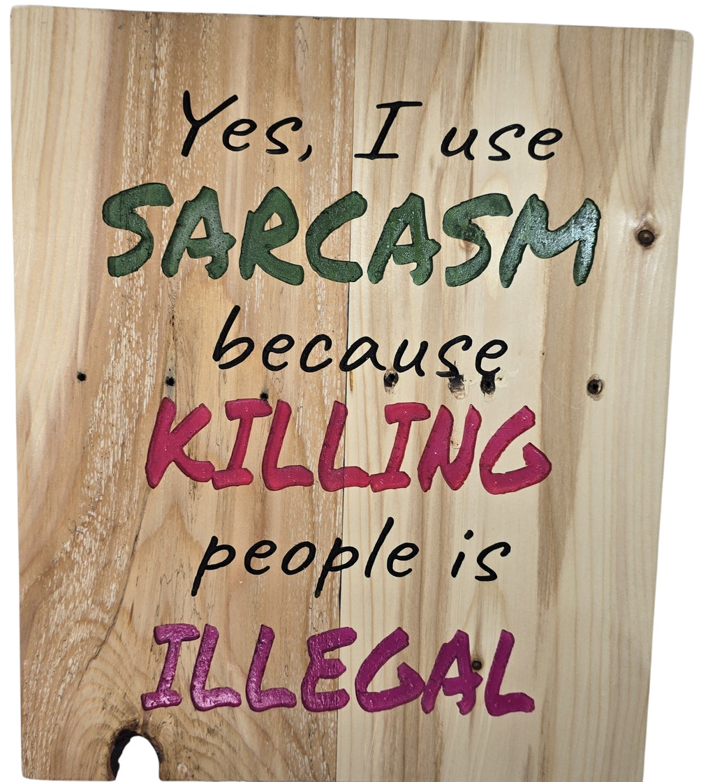 TK Wood Designs natural wood sign with bold green and pink lettering reading "Yes, I use SARCASM because KILLING people is ILLEGAL."