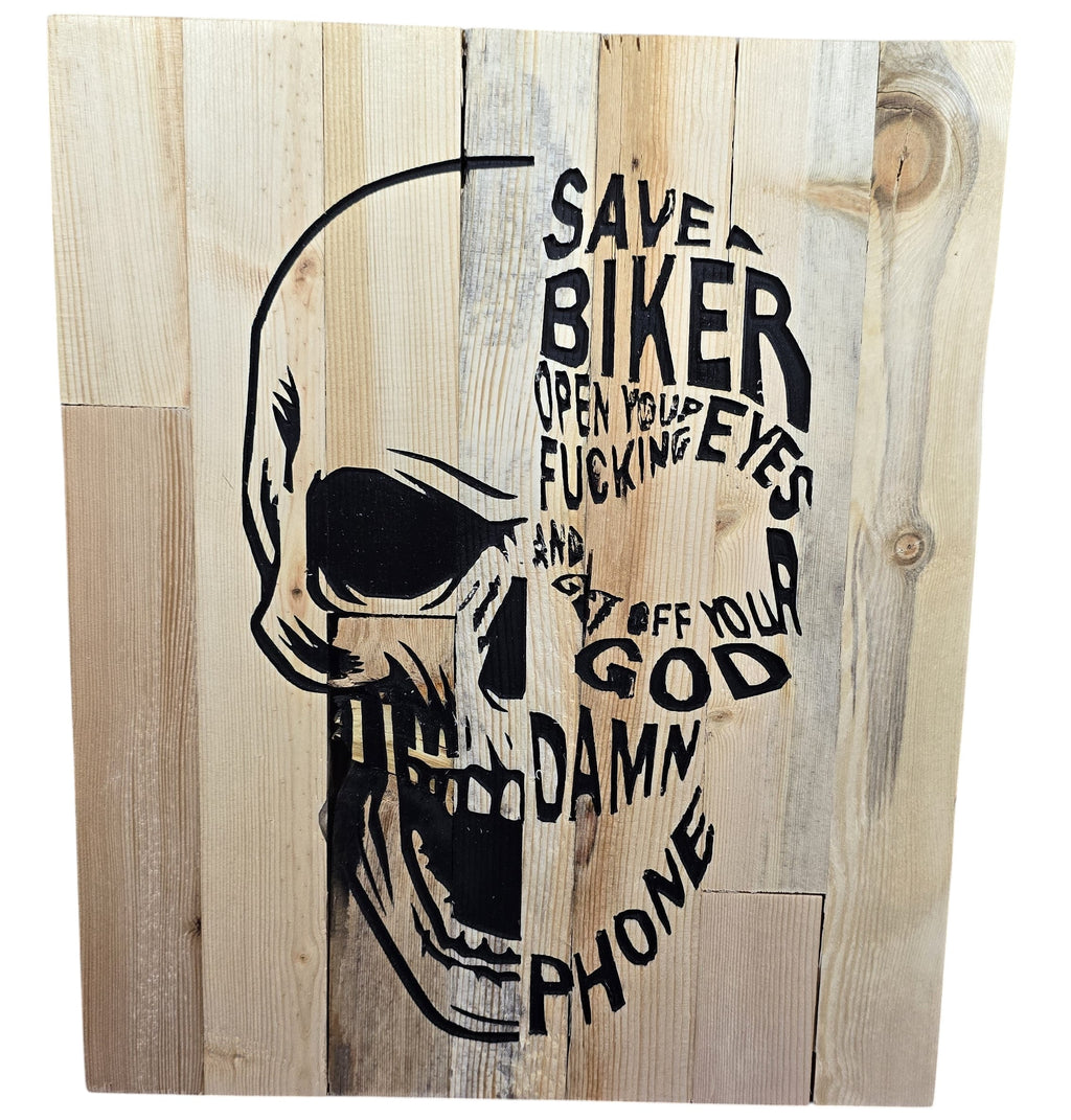TK Wood Designs handcrafted wooden skull art with black text saying "SAVE A BIKER OPEN YOUR FUCKING EYES AND GET OFF YOUR GOD DAMN PHONE".