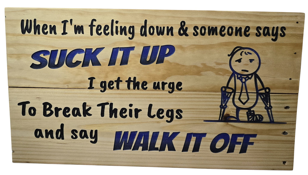 TK Wood Designs humorous wood sign with blue lettering: "Suck It Up Walk It Off" and a stick figure on crutches.