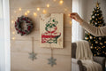 TK Wood Designs rustic wooden wall art sign featuring a festive character on a brick chimney, hung in a holiday setting.