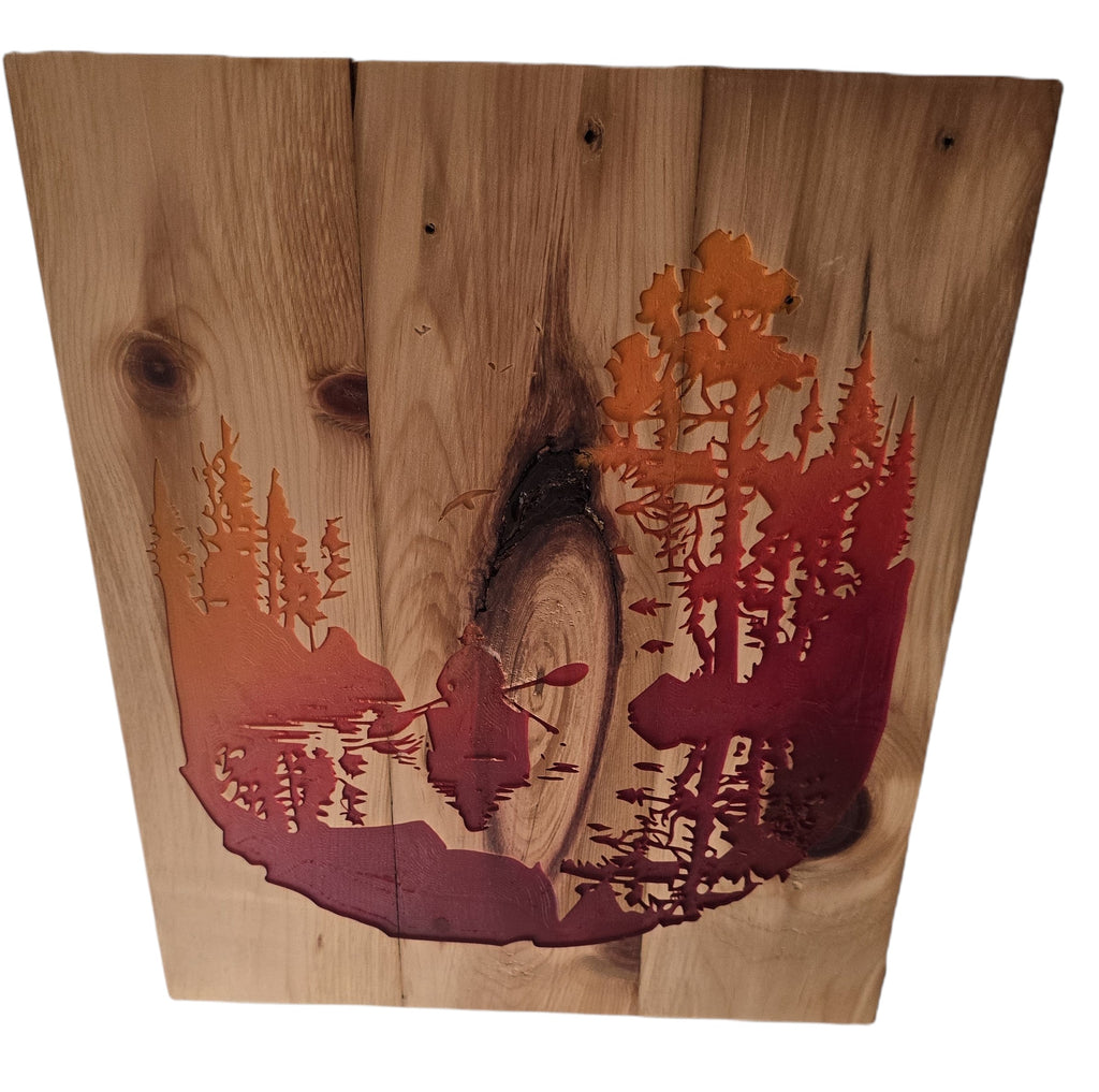 TK Wood Designs rustic woodland scene wall art with a kayaker on a lake, featuring a forest silhouette in orange and red hues on natural wood.