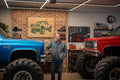 TK Wood Designs green lifted truck wood sign. Features a detailed graphic of a classic pickup truck with large off-road tires and roof lights.