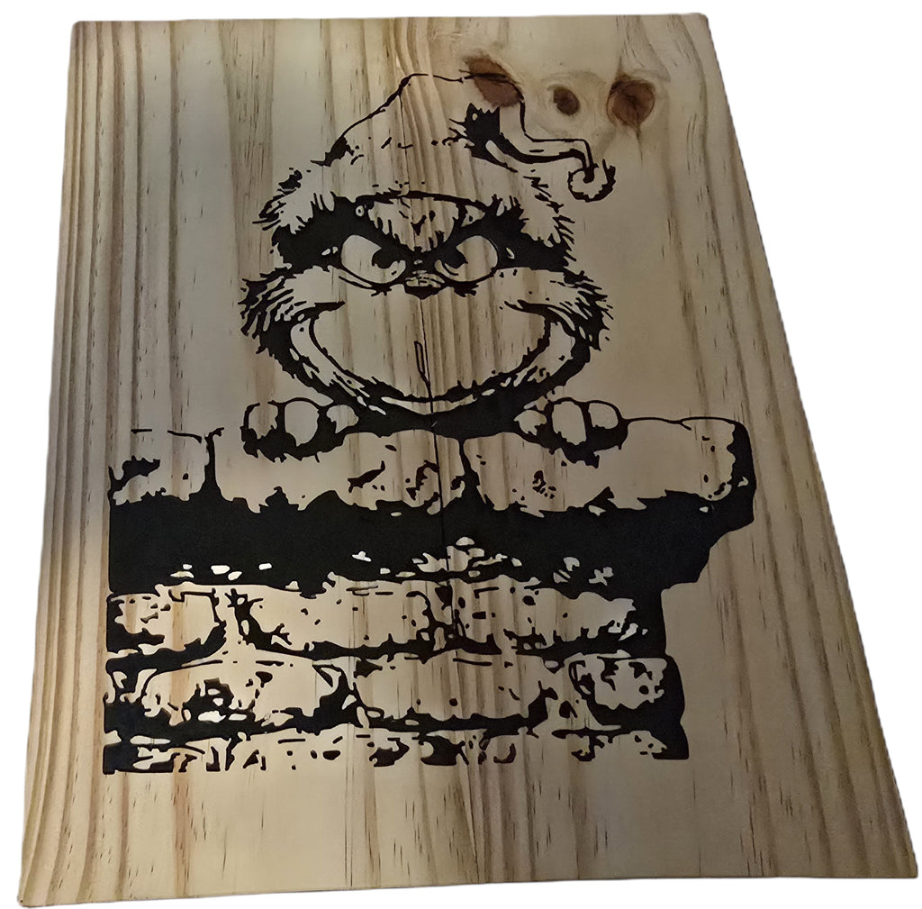 TK Wood Designs Grinch salvaged wood sign with black graphic of the Grinch peeking over a brick wall. Natural wood grain.