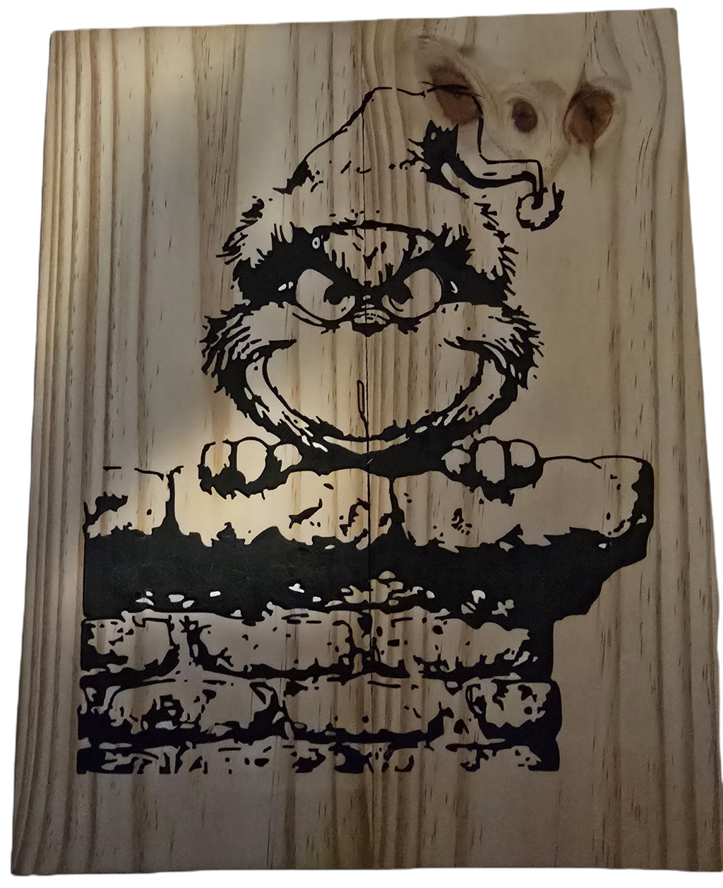 TK Wood Designs Grinch salvaged wood sign with black graphic of the Grinch peeking over a brick wall. Natural wood grain.