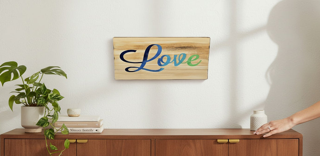 TK Wood Designs reclaimed wood sign with hand-airbrushed blue and green ombre 'Love' text. Natural wood grain.