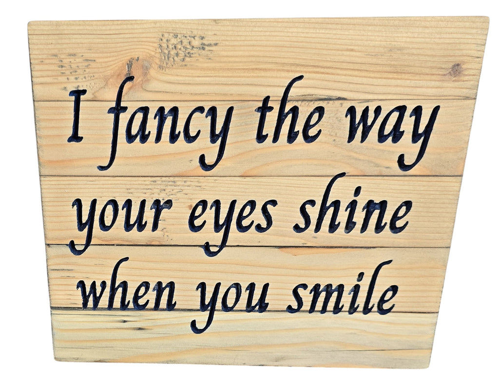 TK Wood Designs reclaimed wood sign with carved text 'I fancy the way your eyes shine when you smile'. Rustic, natural wood finish.
