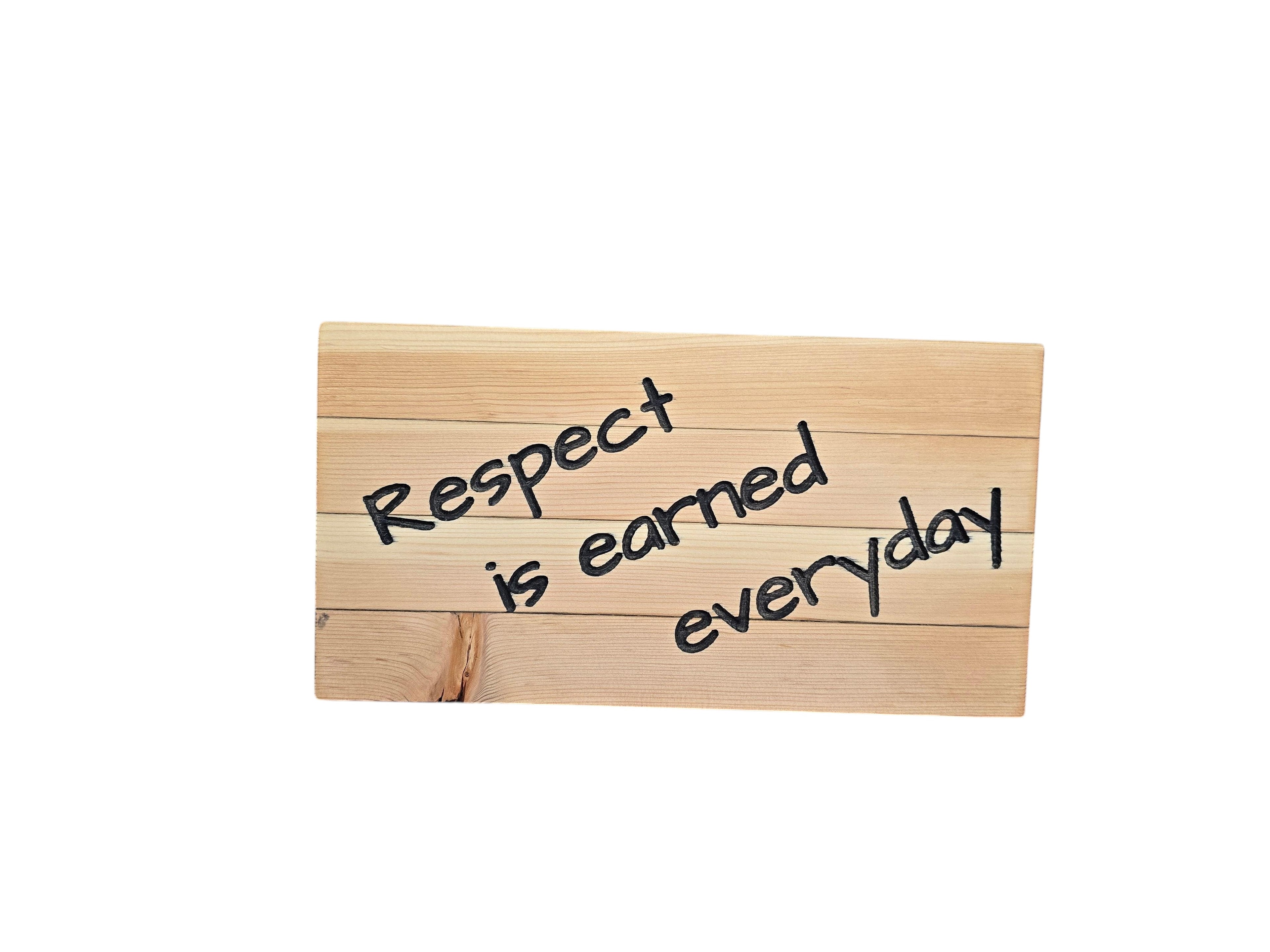 TK Wood Designs wooden sign with carved text 'Respect is earned everyday'. Natural wood finish.