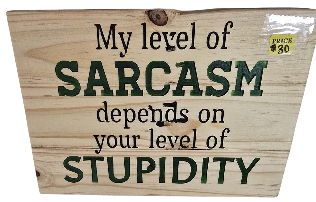 TK Wood Designs natural wood sign with dark green text reading "My level of SARCASM depends on your level of STUPIDITY".